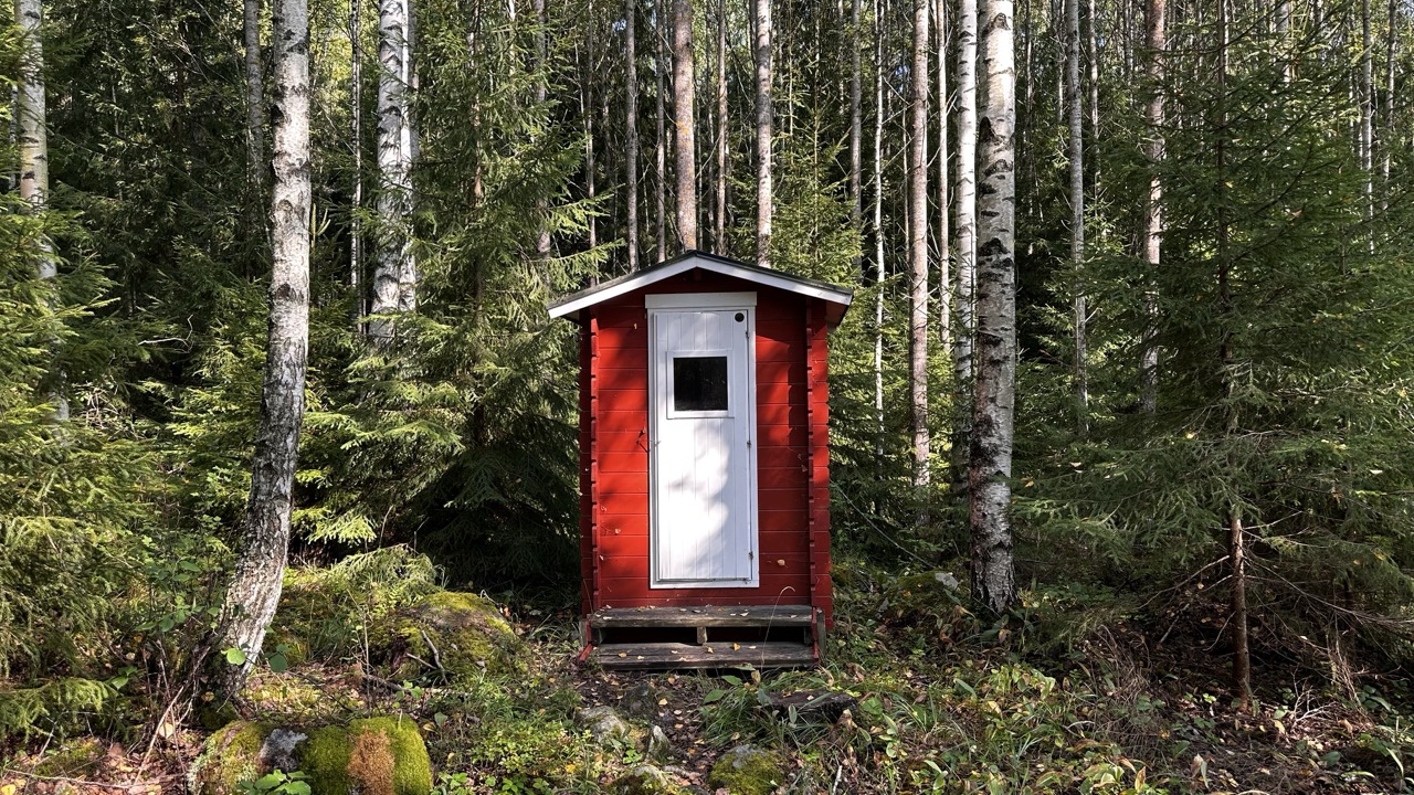 Small building painted red with a white door.