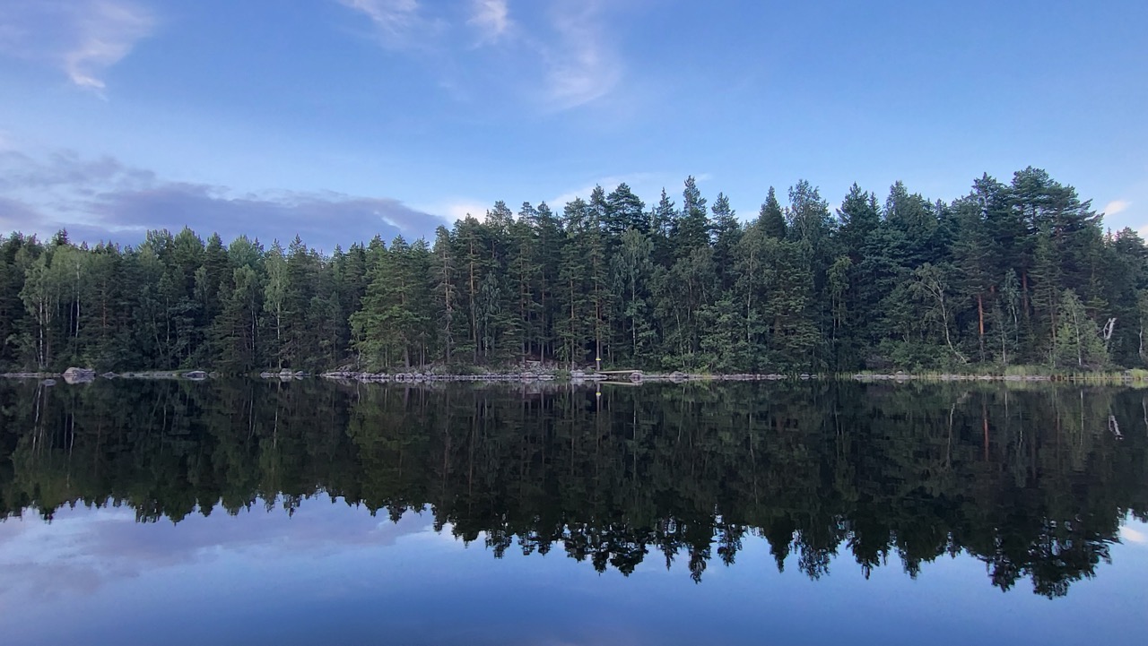 Rannassa näkyy kivikkoa ja pieni laituri.