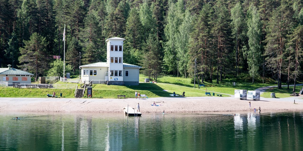 Ahvenistonjärven uimaranta, taustalla olympiarenkailla varustettu kahvilarakennus.