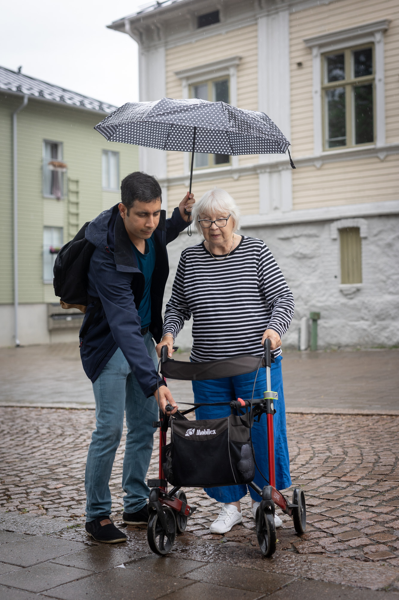 Vapaaehtoinen auttaa ikäihmistä ulkona.