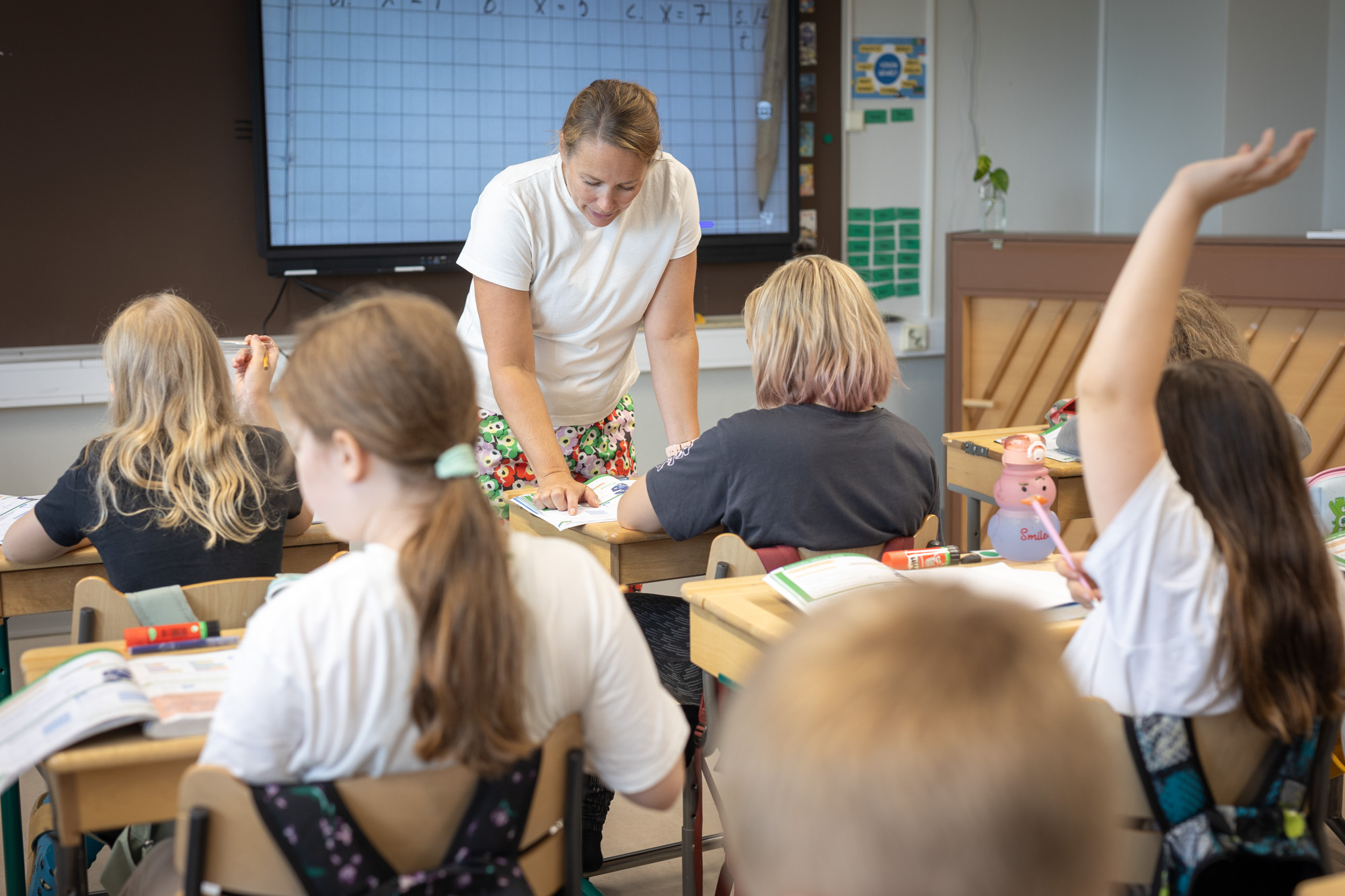 Opettaja opettaa matematiikkaa alakoululaisille.