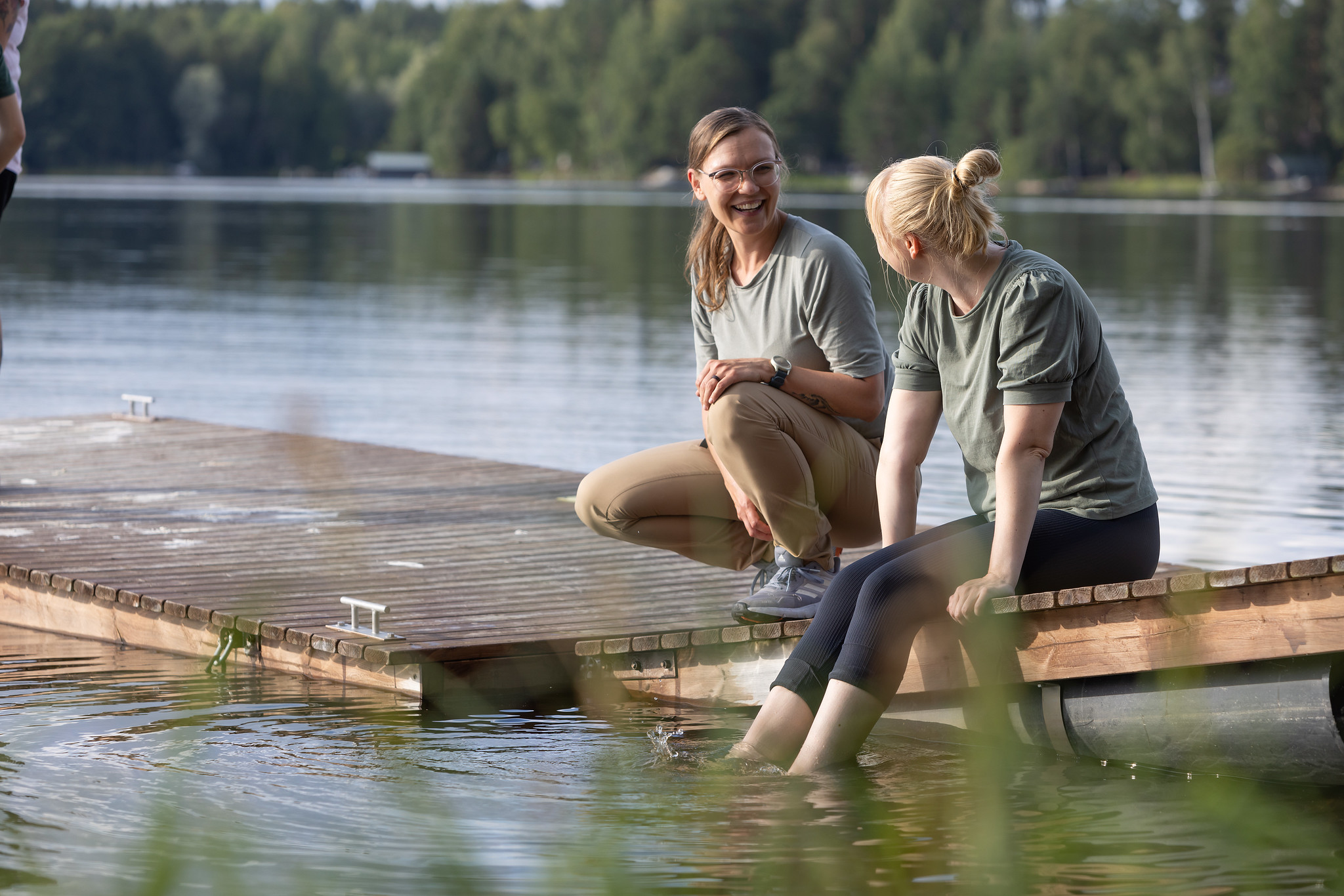 Kaksi ulkoilijaa istuvat laiturilla.