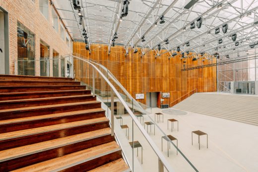 Hämeenlinnan Verkatehtaan aula joka tyhjillään. Korkea ja valoisa tapahtumatilan sisääntuloalue. Materiaaleina yhdistellään puuta, metallia ja lasia.