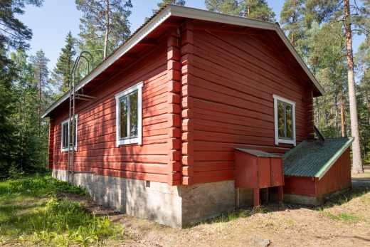 Edessä savottakämppä, joka on metsän keskellä