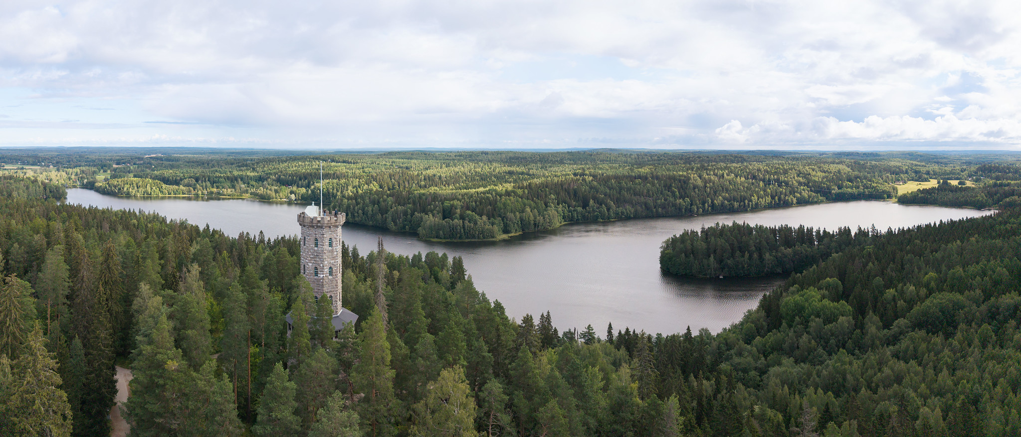Ilmakuvaa Aulangon näköalatornista metsä- ja järvimaiseman keskellä.