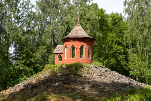 Onnentemppelin tiilirakennus kukkulan päällä puiden ympäröimänä.