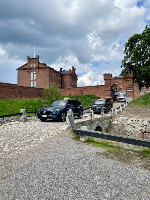 Kaksi taksia ajamassa mukulakivikadulla kohti kuvaajaa.