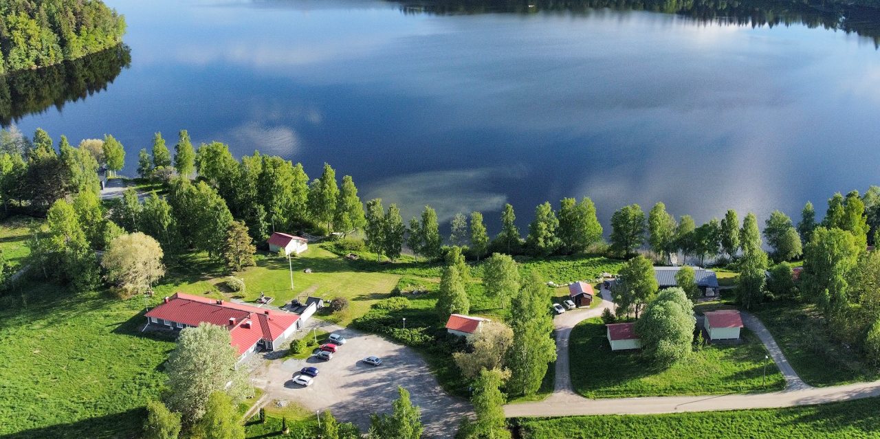 Ilmakuvaa järvinäkymää kohti. Huvilat näkyvät rannassa vehreän alueen keskellä.