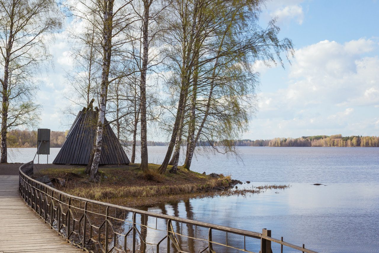 Puinen leveä kävelysilta menee niemen kärkeen kodalle.