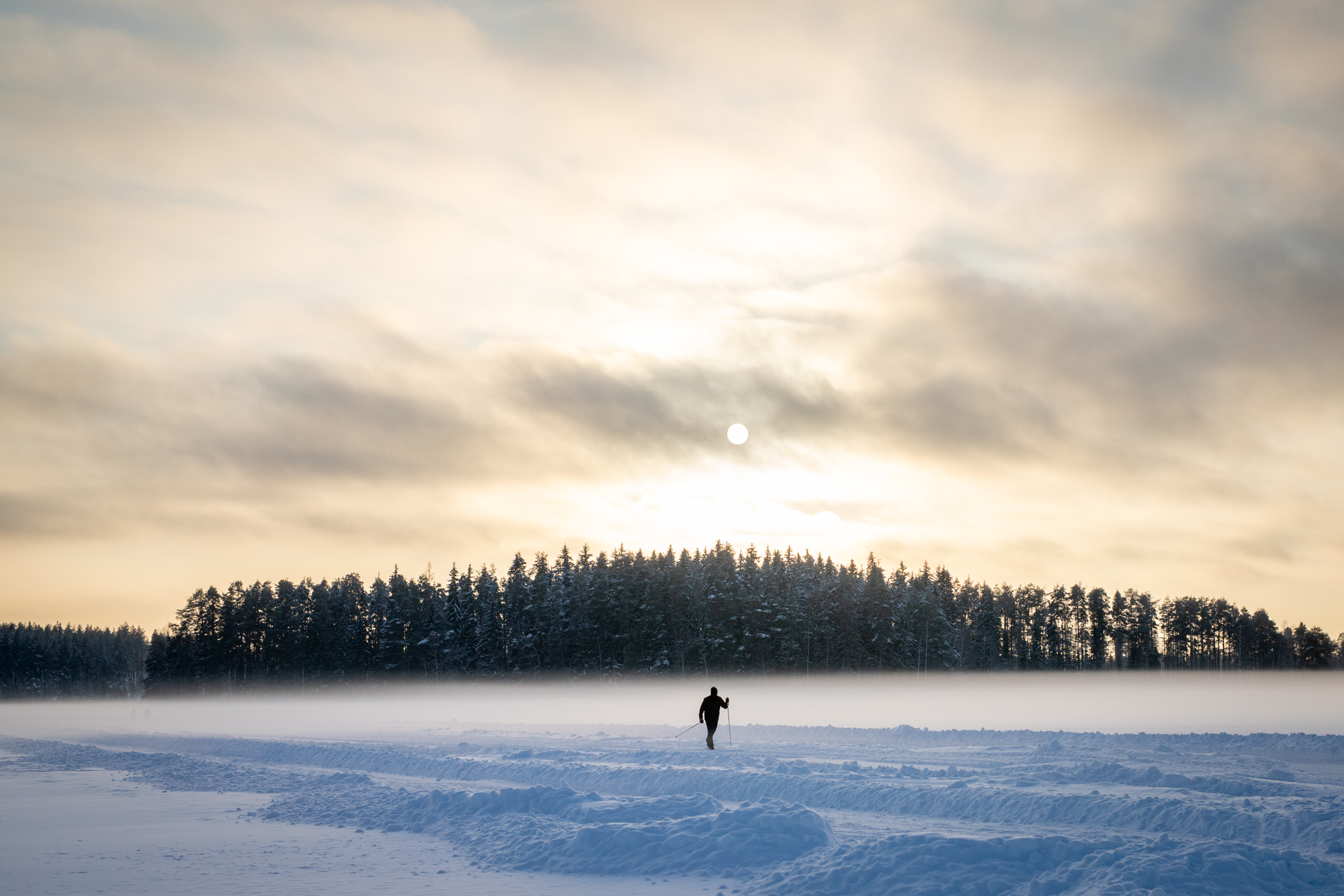 Järven jäällä yksinäinen hiihtäjä