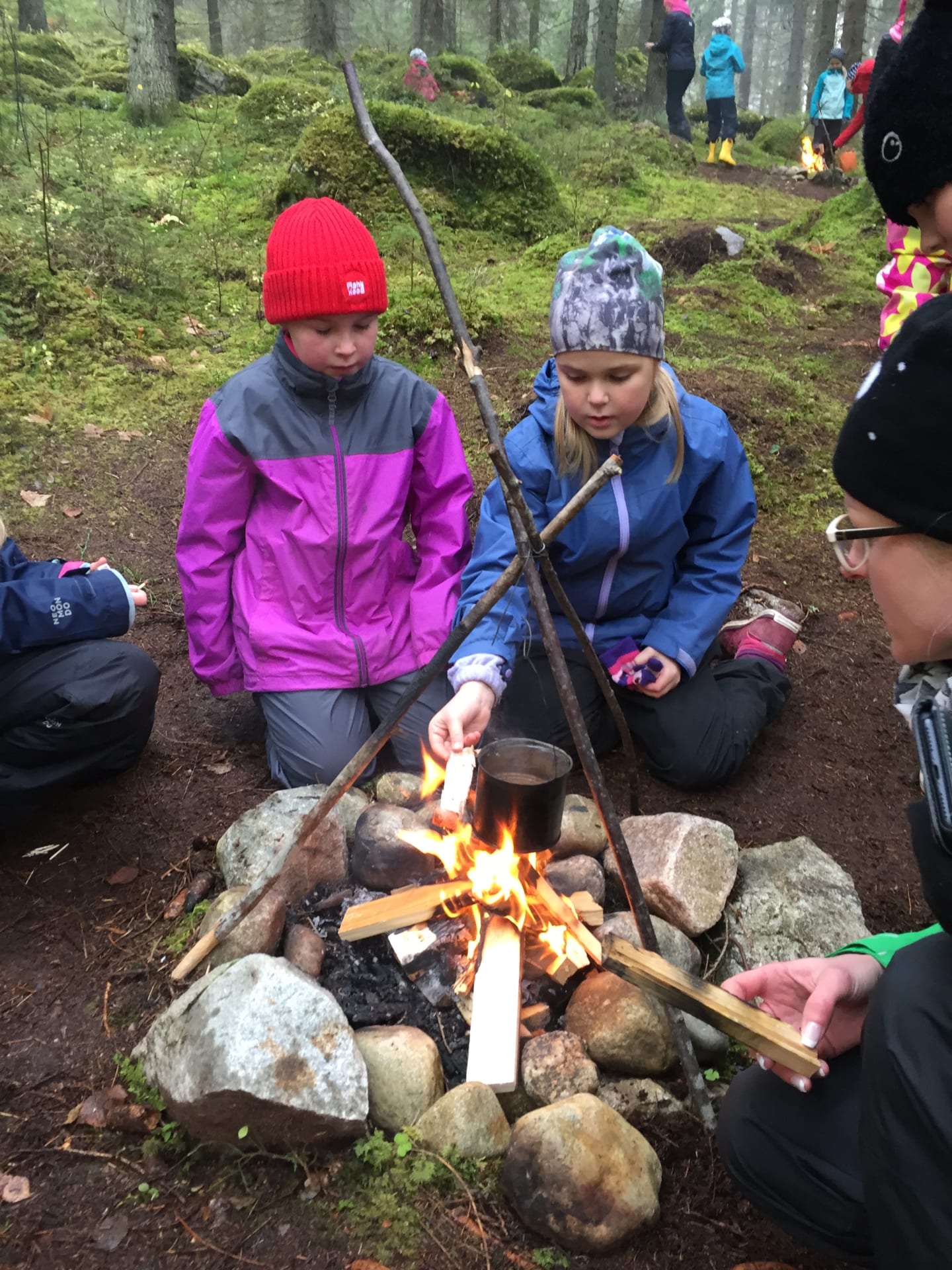 Children are learning by open fire