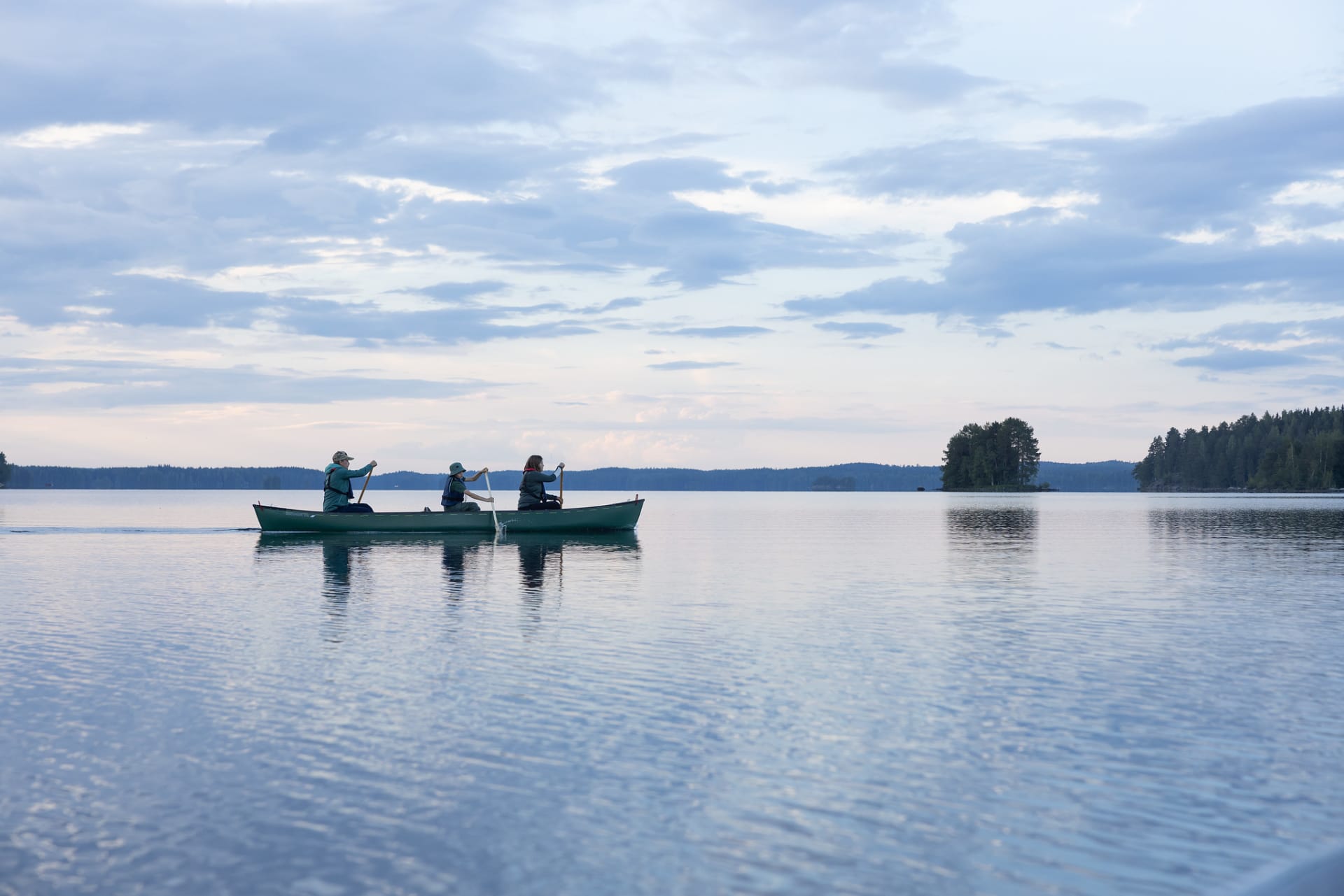 Three people are paddling in a canoe.