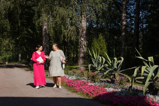 Kaksi henkilöä Porkkalan kartanon puutarhassa.